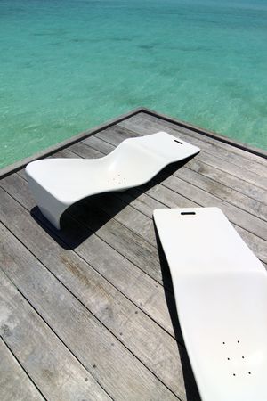 A pair of beach chairs on a wooden platformの写真素材