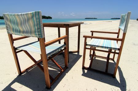A set of beach chairs and table on a beachの写真素材