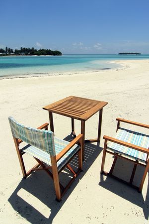 A set of beach chairs and table on a beachの写真素材