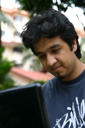 A young man using his laptop outdoorsの写真素材