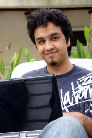 A young man using his laptop outdoorsの写真素材