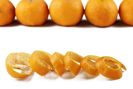 An orange peel with some mandarin oranges in the backgroundの写真素材