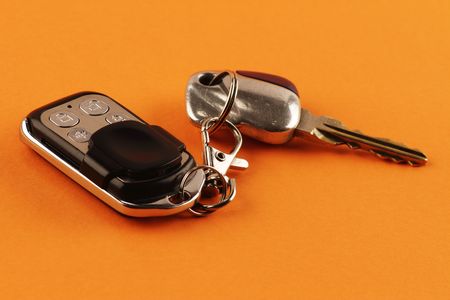 Close-up of a car alarm remote control and car keys on an orange backgroundの写真素材