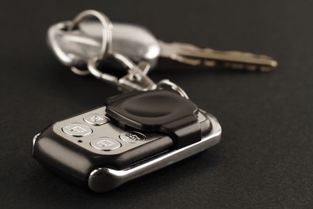 Close-up of a car alarm remote control and car keys on a black backgroundの写真素材