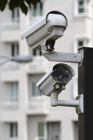 A security camera with LED light monitoring the compound of a residential buildingの写真素材