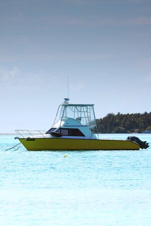 A single boat anchored off an island at Maldivesの写真素材