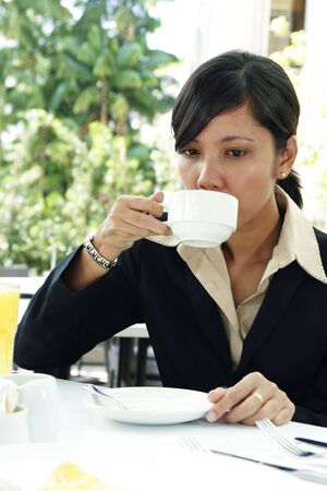 An Asian business executive drinking coffeeの写真素材