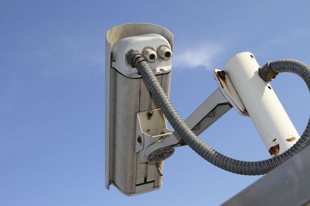Rear view of a security camera against a blue sky