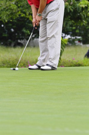 A golfer putting at a golf courseの写真素材