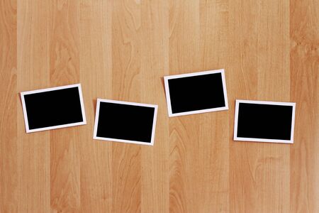 A row of blank photos stuck on a wooden wall. の写真素材