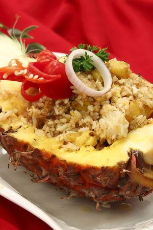 A plate of pineapple fried rice served in a half-cut pineappleの写真素材