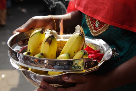 A woman holding a bowl of offerings during the Hindu festival of Thaipusamの写真素材