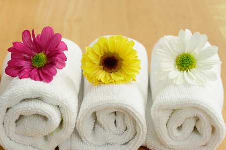 Three spa flowers on top of white towelsの写真素材