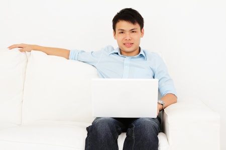 A young Asian man with his laptop at homeの写真素材