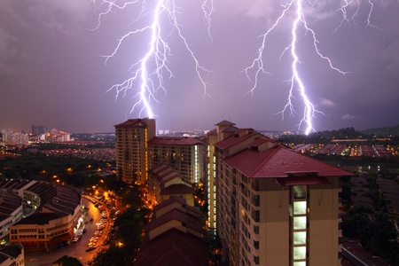 Two lightning bolts strike an urban skyline in Damansara Perdana, Malaysia at nightの写真素材