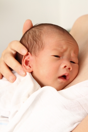 A baby boy looking unhappyの写真素材