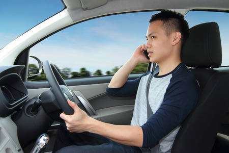 A man driving while talking on a cellphoneの写真素材
