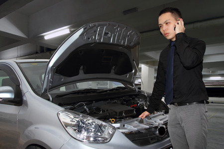 A man calling for help to repair a stalled car