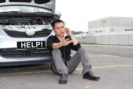 A man calling for help to repair a stalled carの写真素材