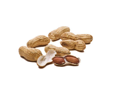 Loose peanuts on a table isolated on white background with drop shadows