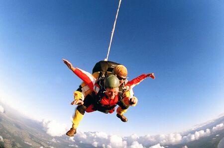 Man and woman skydiving in tandem from an aircraft