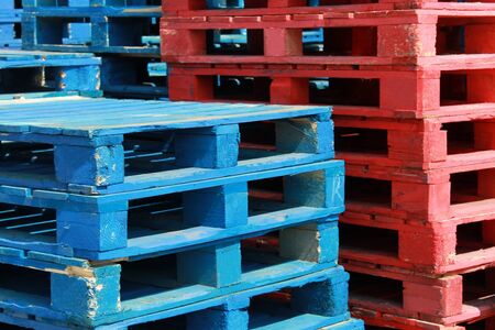 Colorful stacks of red and white crate pallets.の写真素材