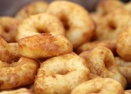Pile of freshly made ring donuts.