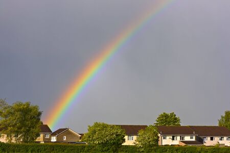 Beautiful rainbow over the rooftopsの写真素材