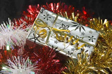 A wrapped Christmas gift surrounded by tinsel