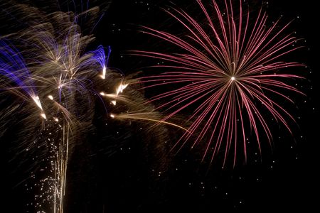 A burst of bright fireworks in the night sky