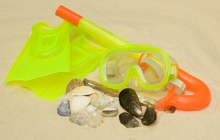 A child's snorkel, mask and flippers laying on the sandの写真素材