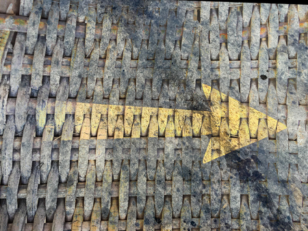 yellow right arrow on the dirty bamboo weaveの写真素材
