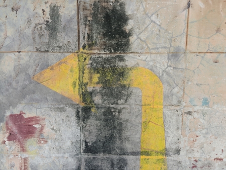 turn left arrow on grunge concrete wall texture