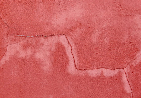 a photography of a red wall with a crack in the middle, red wall with cracks and cracks on it