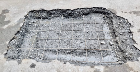 drop - off hole in concrete with wire mesh on cement floor.