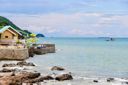 a photography of a beach with a boat in the water, there is a small boat out on the water near a beach.の写真素材