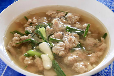 a photography of a bowl of soup with meat and vegetables, there is a bowl of soup with meat and...