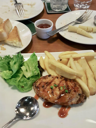 a photography of a plate of food with french fries and a salad, there is a plate of food with french fries and a salad.の写真素材