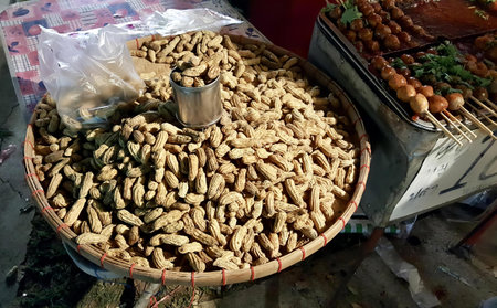 a photography of a basket of peanuts and a basket of chicken, there are many peanuts in a basket on...