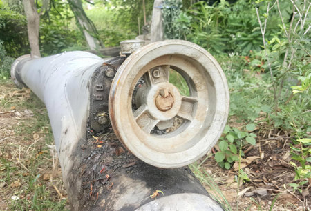 a photography of a pipe with a wheel on it in the woods, there is a pipe that has a wheel on it in...