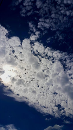 a photography of a plane flying through a cloudy blue sky, there is a plane flying in the sky with a lot of clouds.の写真素材