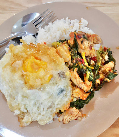 a photography of a plate of food with rice, chicken, and greens, there is a plate of food with rice, chicken, and greens.の写真素材