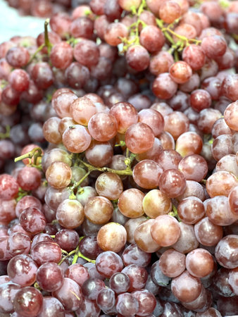 a photography of a bowl of grapes with a bunch of green leaves, a close up of a bowl of grapes with...