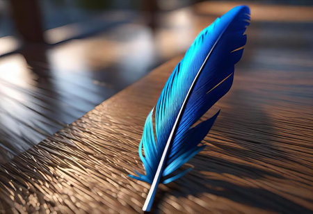 blue feather resting on a wooden table with a blurry background, quill pen on a wooden table with a blurry background.の素材