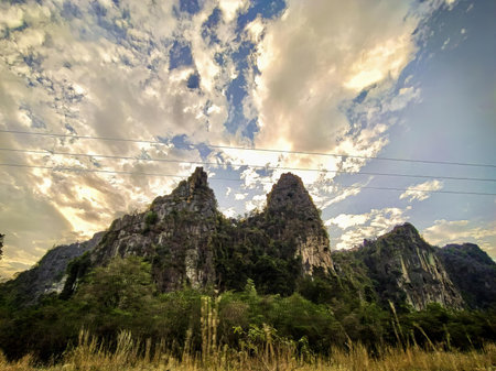 a photography of a mountain with a sky background and some clouds.