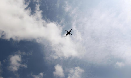 a photography of a plane flying in the sky with a cloud in the background.の写真素材