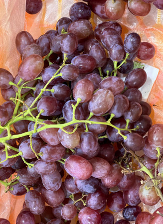 a photography of a bunch of grapes sitting on top of a table, pineapples and grapes are on a table...