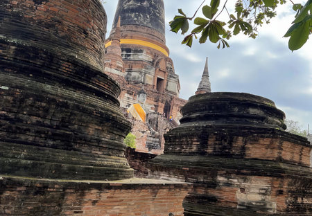 a photography of a person standing on a ledge near a building, stupa kra, a buddhist temple in ayuttpur, thailand.の写真素材