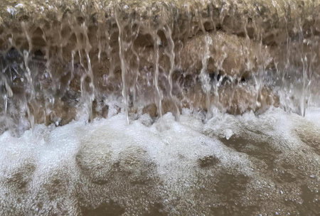 a photography of a waterfall of water flowing over a rock wall, fountain of water flowing over rocks...
