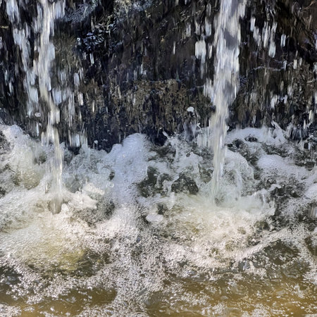 water falling over a rock wall.